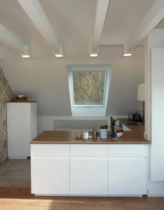 eine Küche mit weißen Schränken und einem Fenster in der Unterkunft Ferienwohnung am Wald - a10692 in Goslar