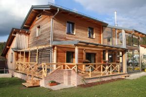 ein großes Holzhaus mit einer großen Terrasse in der Unterkunft Naturhaus Altmuehltal in Emsing