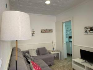 sala de estar con sofá y lámpara en Lleida 25, casa de poble a planta baixa amb àmplia terrassa equipada, en Sant Carles de la Ràpita