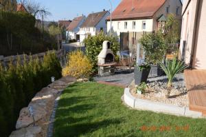 un patio trasero con un jardín con una hoguera en Ferienwohnung Anita, en Rulfingen
