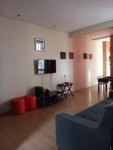 sala de estar con sofá y TV de pantalla plana en excelente apto quarto e sala Ipanema posto 9, en Río de Janeiro