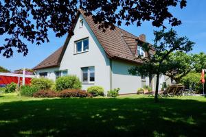 una casa blanca con techo de gambrel en Ferienwohnung Wattfischer, en Cuxhaven