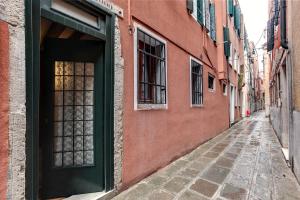 an alley with a green door on a red building at Leo APARTMENT LOC-03081 in Venice