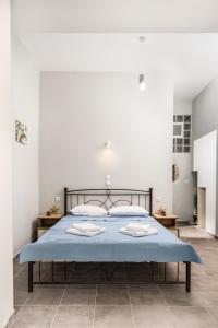 ein Schlafzimmer mit einem Bett mit einer blauen Decke in der Unterkunft Nautilus in Matala