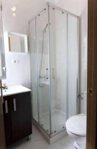 een badkamer met een douche, een toilet en een wastafel bij Dos dormitorios al lado del metro centrico moderno in Madrid