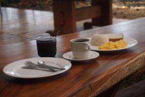 a table with two plates of food and a cup of coffee at La Manigua hostal in Buenaventura