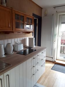 a kitchen with white cabinets and a counter top at Lodge 31 in Neue Tiefe Fehmarn