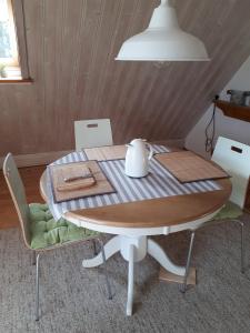 a wooden table with chairs and a tea kettle on it at Lodge 31 in Neue Tiefe Fehmarn