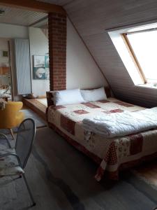 1 dormitorio con 1 cama en un ático con ventana en Lodge 31, en Neue Tiefe Fehmarn