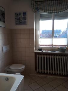 a bathroom with a toilet and a window and a radiator at Lodge 31 in Neue Tiefe Fehmarn