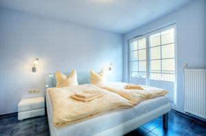 a blue bedroom with a bed with two towels on it at Villa Obendtied, FW 4 in Zingst