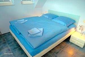 a blue bed with blue sheets and towels on it at Villa Obendtied, FW 4 in Zingst