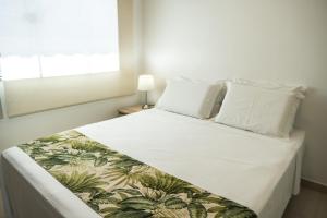 a bedroom with a white bed with a tropical bedspread at Pousada Boipeba Beach in Ilha de Boipeba +38 photos
