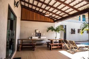 a patio with a table and chairs and a pool at Pousada Boipeba Beach in Ilha de Boipeba