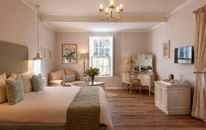 a bedroom with a bed and a living room at L'Auberge Chanteclair in Franschhoek