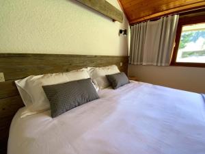 a bedroom with a large white bed with two pillows at Val Du Rio in Le Chambon-sur-Lignon