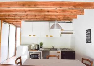 a kitchen with a table and a white refrigerator at Val Du Rio in Le Chambon-sur-Lignon