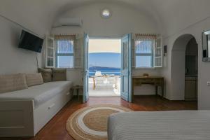 a living room with a couch and a view of the ocean at Petinos traditional house in Therasia
