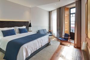 una camera d'albergo con un grande letto e una sedia di Rio da Vila a Porto