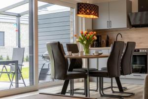 een keuken met een tafel met stoelen en een eetkamer bij Ferienwohnung Sonnenstrahl am Harkebrügger See mit Sauna in Barßel