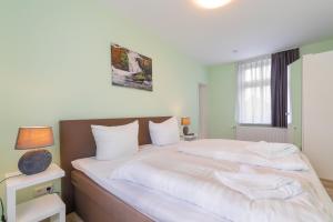 een slaapkamer met een groot bed met witte lakens bij Remise 2 - a44208 in Wernigerode