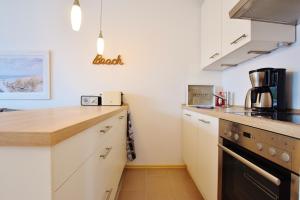 a kitchen with white cabinets and a counter top at FeWo "Lütt Möw" in Dahme