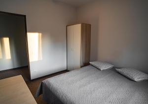 a bedroom with a bed and a cabinet and a mirror at Vėjo Malūnų sodyba - vila in Paserninkai