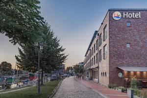 an empty street next to a brick building with a hotel at Hotel Stadthafen Stade in Stade