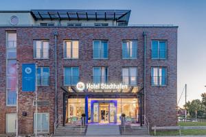 a red brick building with a hotel sandwich at Hotel Stadthafen Stade in Stade
