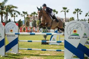 a person riding a horse jumping over an obstacle at Brisa de Mar en Oliva Nova, junto a MET y golf in Oliva