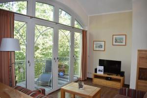 a living room with a sliding glass door with a balcony at Villa Carina "Carina's 922" in Baabe