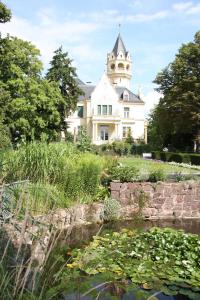 a large white house with a pond in front of it at Apartment am Kunsthaus Nordhausen in Nordhausen