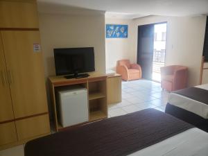 ein Hotelzimmer mit einem Bett und einem TV in der Unterkunft Gran Roza Hotel in Patos de Minas