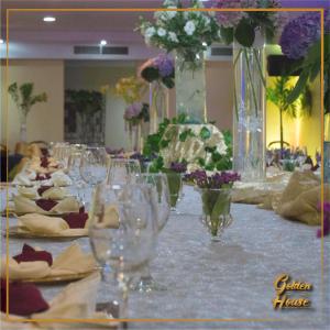 una mesa larga con copas de vino y flores. en Golden House Hotel & Convention Center, en Santo Domingo