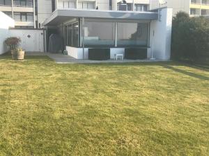 a house with a lawn in front of a building at Fehmarn-Ostseeferien FH3Bungalow am Südstrand 138 in Burgtiefe auf Fehmarn 