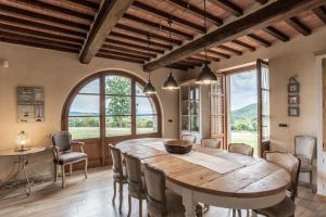 a dining room with a large wooden table and chairs at Podere Ortaglia di Sopra in Castiglion Fiorentino