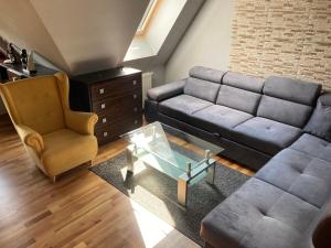 ein Wohnzimmer mit einem Sofa und einem Stuhl in der Unterkunft Apartament Platinum in Zakopane