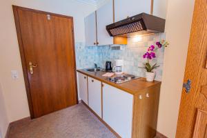eine kleine Küche mit einer Spüle und einer Theke in der Unterkunft Soldanella 3 by Alpenidyll Apartments in Ramsau am Dachstein