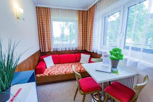 ein Wohnzimmer mit einem roten Sofa und einem Tisch in der Unterkunft Soldanella 3 by Alpenidyll Apartments in Ramsau am Dachstein