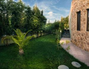 a small palm tree in a yard next to a building at Abbacy Katiana's Castelleti 1 in Limenas