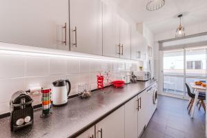 a kitchen with white cabinets and a counter top at The Millennial Lifestyle Apartment in Funchal