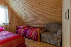 - une chambre avec 2 lits jumeaux et une chaise dans l'établissement Sodyba "Baltalaukis", à Didžiosios Kabiškės