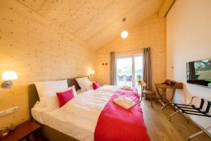 ペルツァーハケンにあるTyp E plus "Preußen" -P-Liner-Haus-の木製の部屋に大型ベッドが備わるベッドルーム1室が備わります。