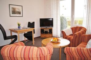 a living room with two chairs and a television at An der Allee 20 A in Dahme
