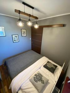 1 dormitorio con 1 cama con 2 almohadas y luces en Apartament Platinum, en Zakopane