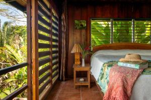 1 dormitorio con 1 cama en una cabaña de madera en Tiskita Jungle Lodge, en Pavones