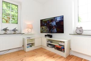 a living room with a flat screen tv on a white wall at Badestraße 72 in Wyk auf Föhr