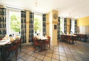 a restaurant with tables and chairs and a clock on the wall at Hotel Hansehof in Hamburg