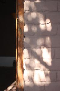 a brick wall with a wooden door and a brick wall behind it at Hotel Kimal in San Pedro de Atacama