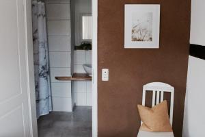 un pasillo con una silla blanca junto a una pared en Landhaus Weserbergland - Anton, en Vahlbruch